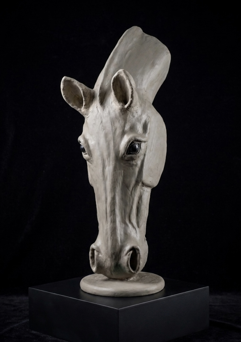 Hand-sculpted unpainted clay horse-head sculpture of Soul on black plinth